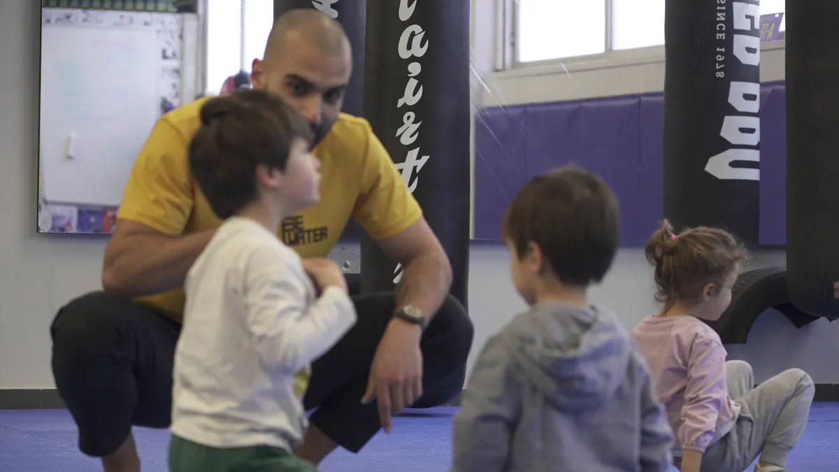 Coach com grupo de crianças no ginásio